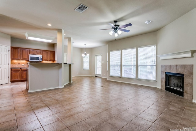 3501 Big Horn, Schertz, TX 78154 - unfurnished living room with a ceiling fan, a fireplace, a chandelier, light tile patterned floors, and recessed lighting