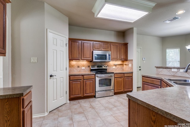 3501 Big Horn, Schertz, TX 78154 - kitchen with appliances with stainless steel finishes, tasteful backsplash, brown cabinetry, light tile patterned floors, and recessed lighting