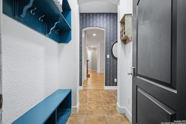 1162 Thunder Cloud, Spring Branch, TX 78070 - hallway featuring arched walkways, a textured wall, tile patterned floors, and wallpapered walls