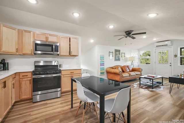 1162 Thunder Cloud, Spring Branch, TX 78070 - kitchen featuring appliances with stainless steel finishes, a wall unit AC, light brown cabinets, lofted ceiling, and light wood-style flooring