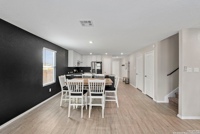 6041 Vestige Bnd, Bulverde, TX 78163 - dining room with light wood-style flooring, stairs, and recessed lighting