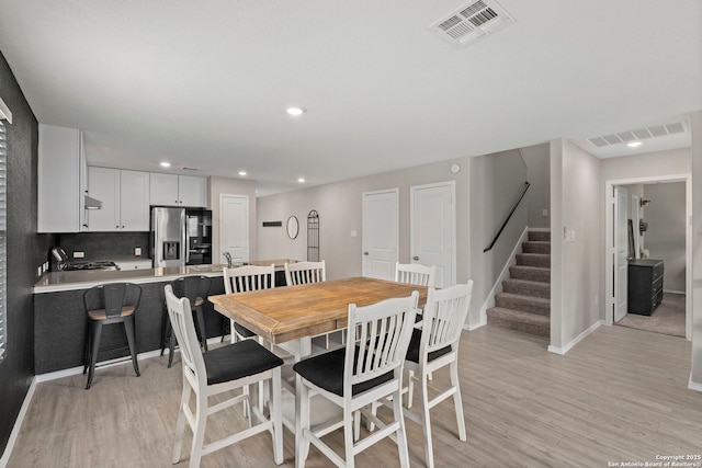 6041 Vestige Bnd, Bulverde, TX 78163 - dining space featuring light wood-style flooring, stairway, and recessed lighting