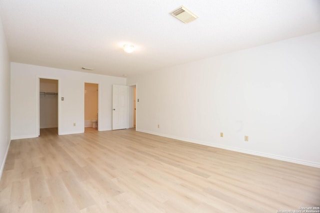5510 Camry Spgs, San Antonio, TX 78251 - unfurnished bedroom with light wood-style flooring and a walk in closet
