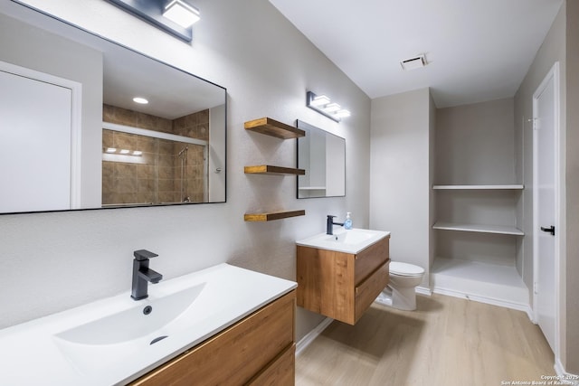 16738 Stoney Glade, San Antonio, TX 78247 - bathroom featuring wood finished floors, two vanities, and a tile shower