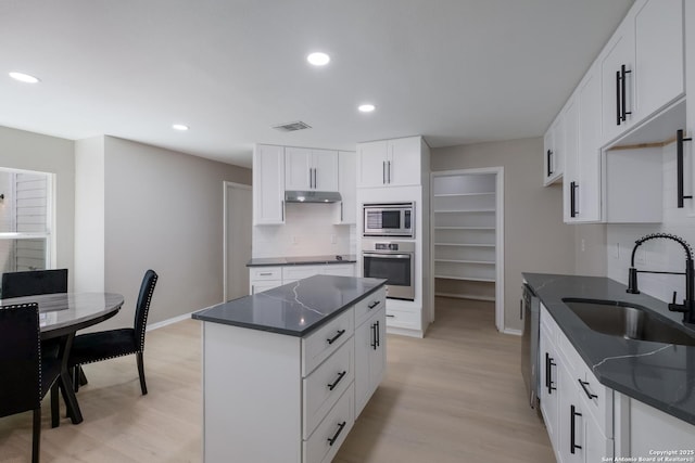 16738 Stoney Glade, San Antonio, TX 78247 - kitchen with stainless steel appliances, dark countertops, light wood-style floors, recessed lighting, and a kitchen island
