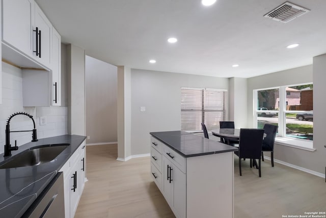 16738 Stoney Glade, San Antonio, TX 78247 - kitchen with dark countertops, dishwashing machine, light wood finished floors, recessed lighting, and decorative backsplash