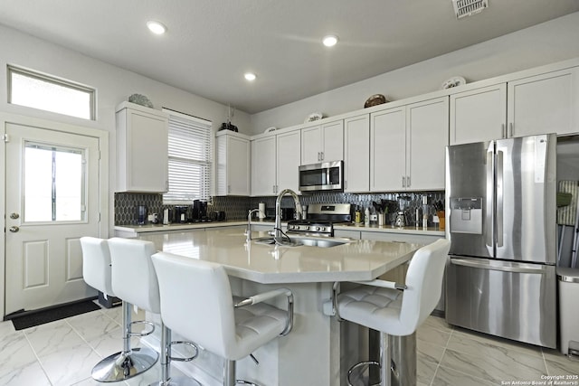 4439 Tiger Run, San Antonio, TX 78217 - kitchen with stainless steel appliances, light marble finish flooring, a breakfast bar area, light countertops, and recessed lighting