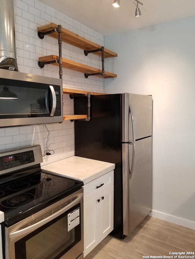 908 Camaron St, San Antonio, TX 78212 - kitchen featuring stainless steel appliances, open shelves, backsplash, light countertops, and white cabinetry