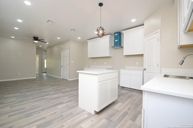 165 N San Felipe, San Antonio, TX 78237 - kitchen with wall chimney range hood, a ceiling fan, light wood-type flooring, recessed lighting, and white cabinets
