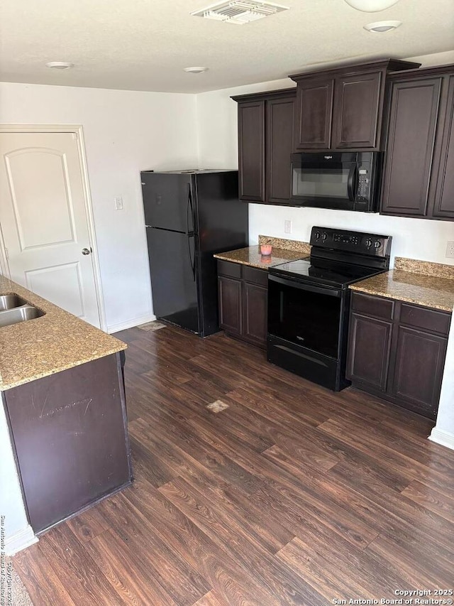 6135 Lakefront, San Antonio, TX 78222 - kitchen with black appliances, dark wood-type flooring, dark brown cabinetry, and light stone counters
