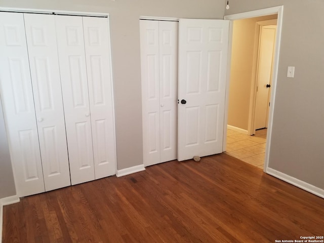 310 Coronet, San Antonio, TX 78216 - unfurnished bedroom featuring multiple closets and wood finished floors