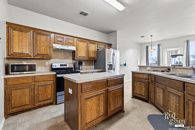6027 Still Mdw, San Antonio, TX 78222 - kitchen with stainless steel appliances, under cabinet range hood, brown cabinets, decorative backsplash, and a center island