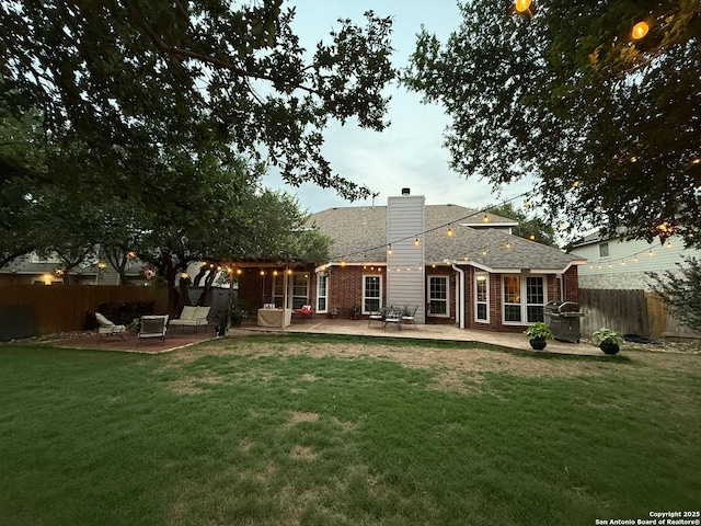 13011 Vidorra Vis, San Antonio, TX 78216 - back of house with a patio area, a chimney, brick siding, and a shingled roof
