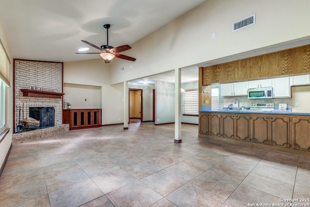 10615 Bar X Trl, San Antonio, TX 78023 - unfurnished living room featuring a ceiling fan, a fireplace, high vaulted ceiling, and recessed lighting