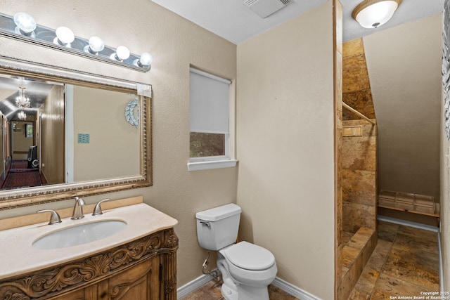 6033 Cammie, Leon Valley, TX 78238 - bathroom featuring tiled shower, vanity, and stone tile flooring