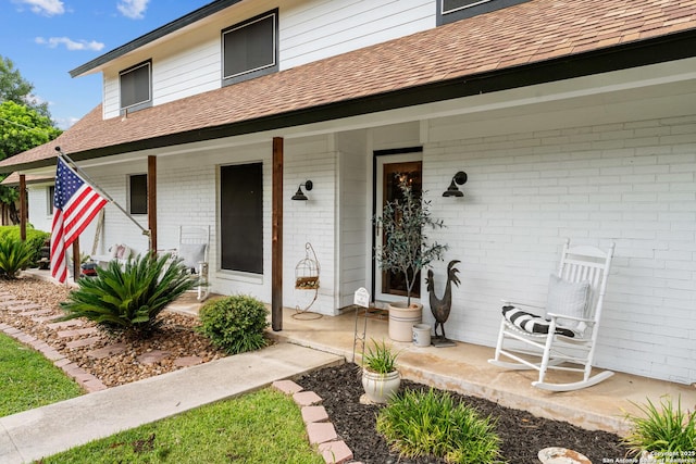 6033 Cammie, Leon Valley, TX 78238 - property entrance with a porch, roof with shingles, and brick siding