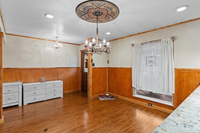 6033 Cammie, Leon Valley, TX 78238 - unfurnished dining area featuring a chandelier, wainscoting, crown molding, wood finished floors, and wooden walls