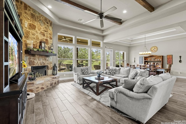 1117 Provence Pl, New Braunfels, TX 78132 - living room featuring a raised ceiling, a ceiling fan, a fireplace, wood finished floors, and beam ceiling