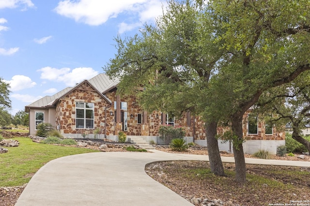 1117 Provence Pl, New Braunfels, TX 78132 - view of front of home featuring a standing seam roof, stone siding, a metal roof, and a front lawn