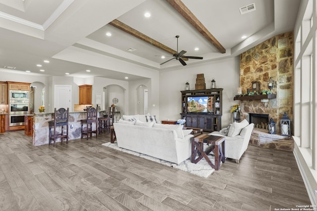 1117 Provence Pl, New Braunfels, TX 78132 - living area featuring arched walkways, ceiling fan, recessed lighting, beamed ceiling, and a stone fireplace