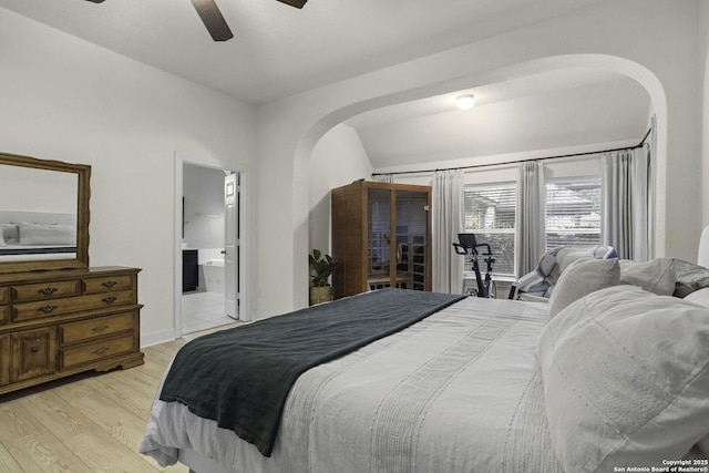 10657 Foxen Way, Helotes, TX 78023 - bedroom with arched walkways, light wood-type flooring, ensuite bath, and ceiling fan