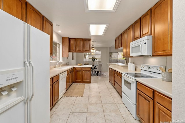 14310 Fox Fire Ln, San Antonio, TX 78231 - kitchen featuring white appliances, brown cabinets, light countertops, plenty of natural light, and recessed lighting