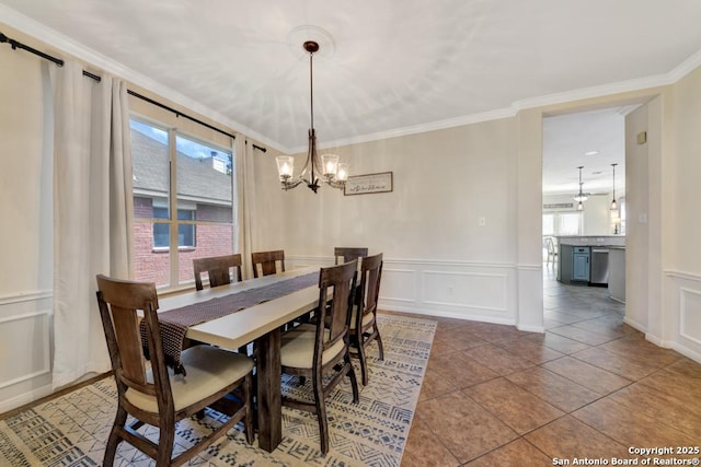 2043 Belvedere, New Braunfels, TX 78130 - tiled dining space featuring a decorative wall, a chandelier, a wainscoted wall, and crown molding