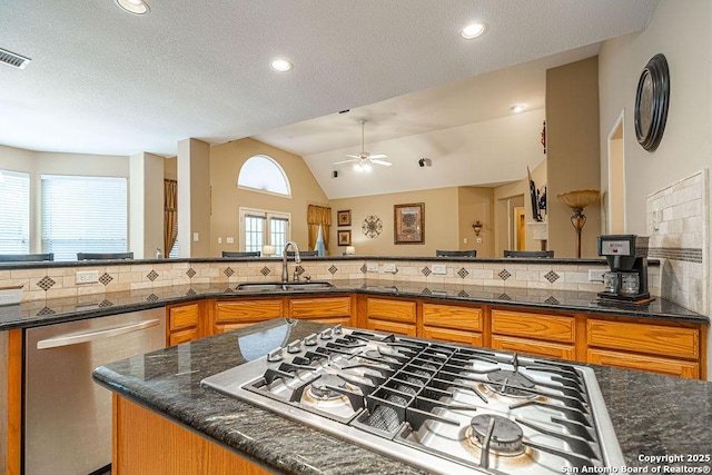 26304 Tiffnilee, San Antonio, TX 78255 - kitchen with stainless steel appliances, brown cabinets, a ceiling fan, backsplash, and a textured ceiling