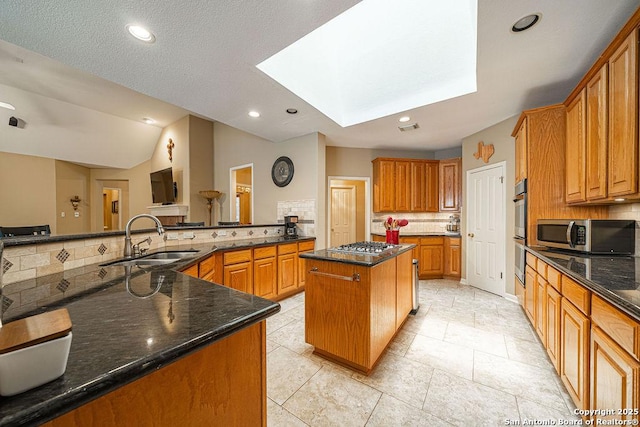26304 Tiffnilee, San Antonio, TX 78255 - kitchen featuring appliances with stainless steel finishes, a skylight, a kitchen island, decorative backsplash, and dark stone counters