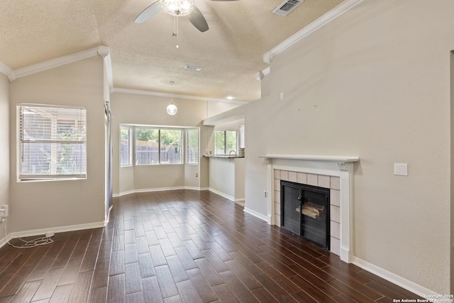 4242 Shady Tree Ln, San Antonio, TX 78247 - unfurnished living room with a textured ceiling, ceiling fan, a tile fireplace, crown molding, and dark wood-type flooring