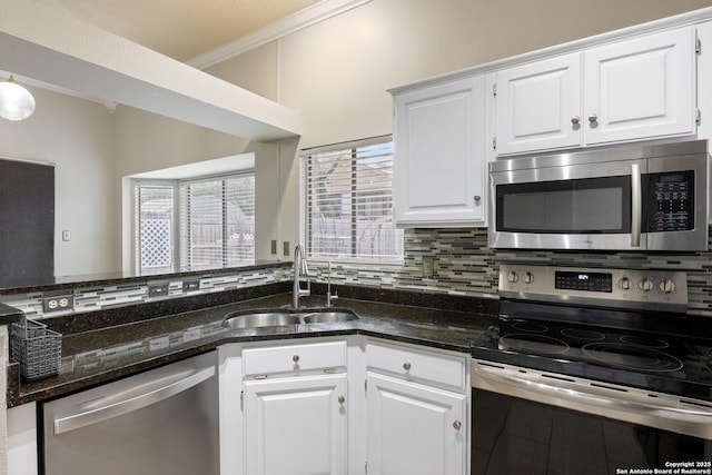 4242 Shady Tree Ln, San Antonio, TX 78247 - kitchen with stainless steel appliances, decorative backsplash, white cabinets, dark stone counters, and ornamental molding