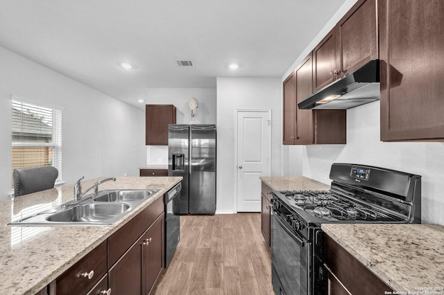 14016 Breccia Loop, San Antonio, TX 78253 - kitchen with black range with gas stovetop, refrigerator with ice dispenser, under cabinet range hood, light wood-type flooring, and dark brown cabinetry