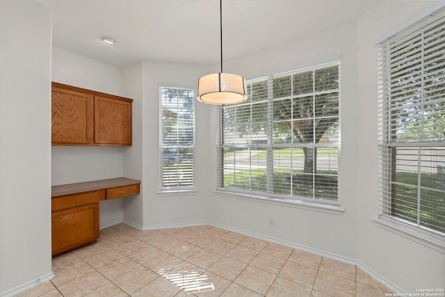 665 La Bahia Loop, New Braunfels, TX 78132 - unfurnished dining area featuring built in study area and light tile patterned floors