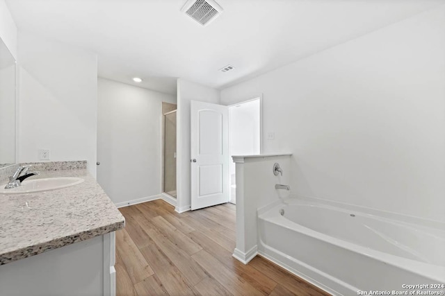 10950 Lafayette Loop, San Antonio, TX 78109 - full bathroom featuring a garden tub, vanity, a shower stall, wood finished floors, and recessed lighting