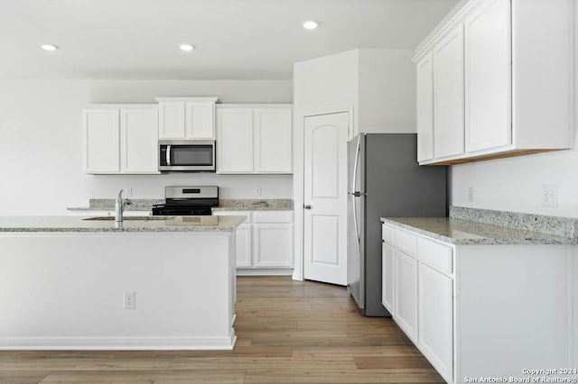 10950 Lafayette Loop, San Antonio, TX 78109 - kitchen with appliances with stainless steel finishes, white cabinetry, light stone countertops, wood finished floors, and recessed lighting