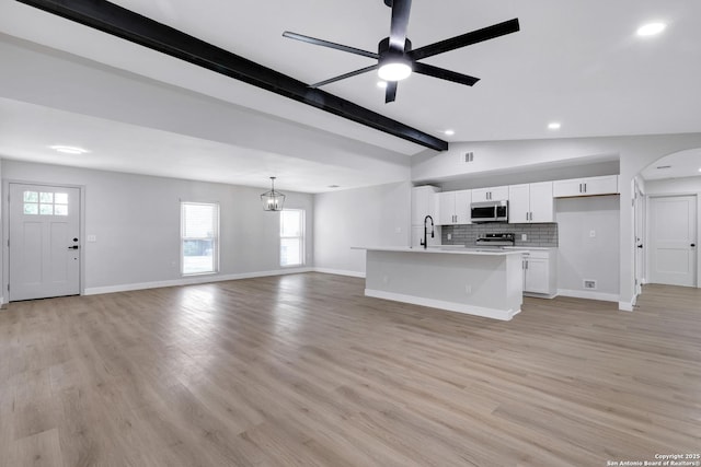 5807 Sun Rdg, San Antonio, TX 78247 - unfurnished living room with a ceiling fan, arched walkways, recessed lighting, light wood finished floors, and a chandelier
