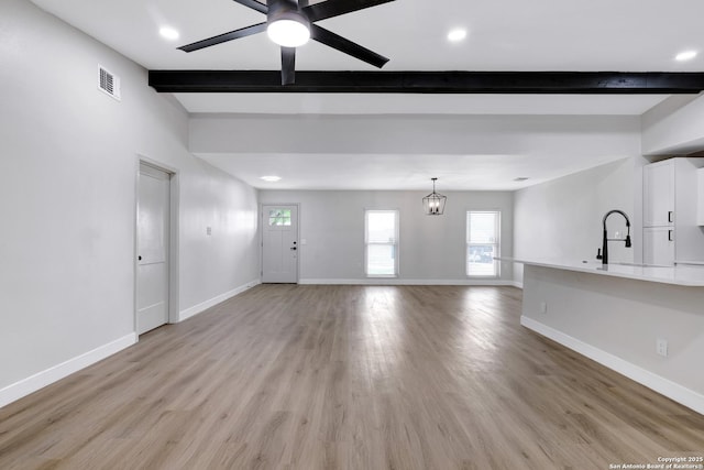 5807 Sun Rdg, San Antonio, TX 78247 - unfurnished living room with beamed ceiling, a ceiling fan, light wood-style floors, healthy amount of natural light, and recessed lighting