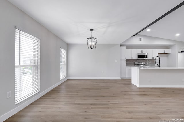 5807 Sun Rdg, San Antonio, TX 78247 - kitchen featuring appliances with stainless steel finishes, a chandelier, white cabinets, light countertops, and tasteful backsplash