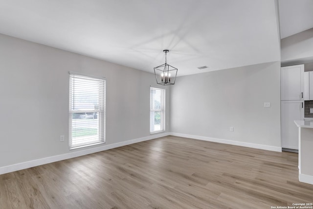 5807 Sun Rdg, San Antonio, TX 78247 - unfurnished room with healthy amount of natural light, a chandelier, and light wood-style flooring