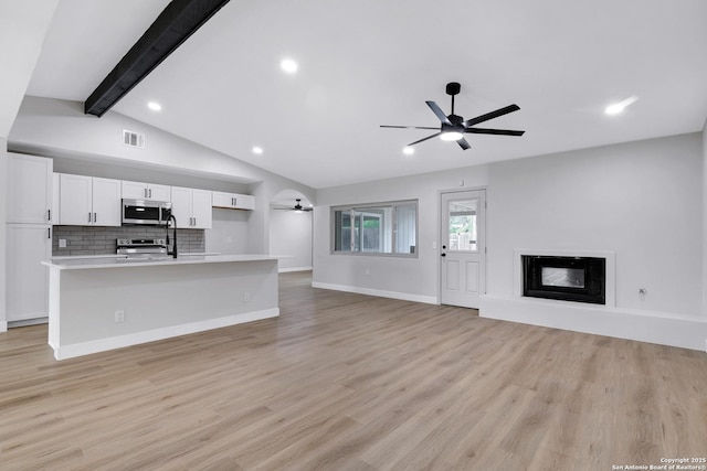 5807 Sun Rdg, San Antonio, TX 78247 - unfurnished living room featuring a ceiling fan, a glass covered fireplace, light wood-style floors, and recessed lighting