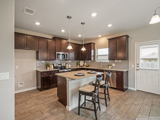 754 Farmers Dell, New Braunfels, TX 78130 - kitchen with appliances with stainless steel finishes, dark brown cabinetry, light wood finished floors, tasteful backsplash, and recessed lighting