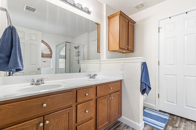 5938 Smoky Quartz, San Antonio, TX 78222 - full bathroom featuring wood finished floors, double vanity, and a stall shower