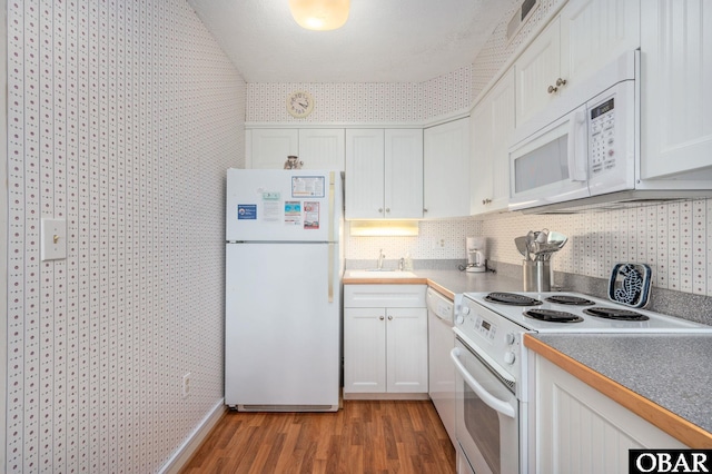 117 Sea Colony Dr Unit 211B, Duck, NC 27949 - kitchen with a sink, light wood-style floors, white appliances, white cabinetry, and wallpapered walls