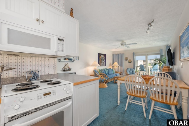 117 Sea Colony Dr Unit 211B, Duck, NC 27949 - kitchen featuring white cabinets, ceiling fan, white appliances, carpet, and open floor plan