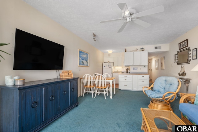 117 Sea Colony Dr Unit 211B, Duck, NC 27949 - living area with carpet floors, a ceiling fan, a textured ceiling, and visible vents