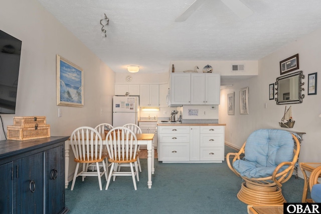 117 Sea Colony Dr Unit 211B, Duck, NC 27949 - dining space featuring ceiling fan, dark carpet, a textured ceiling, and visible vents