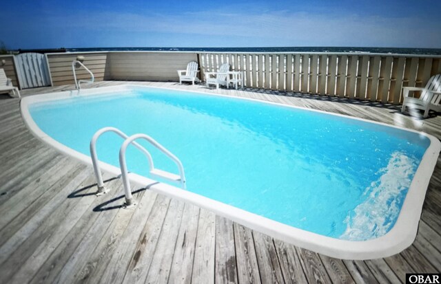 view of swimming pool featuring a deck with water view