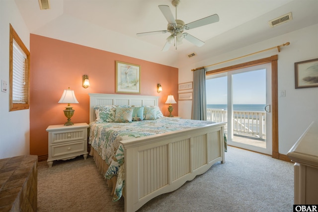 bedroom featuring visible vents, a water view, light colored carpet, and access to outside