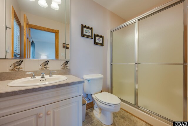 bathroom with toilet, a stall shower, and vanity