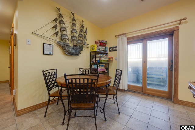 dining space featuring light tile patterned floors and baseboards